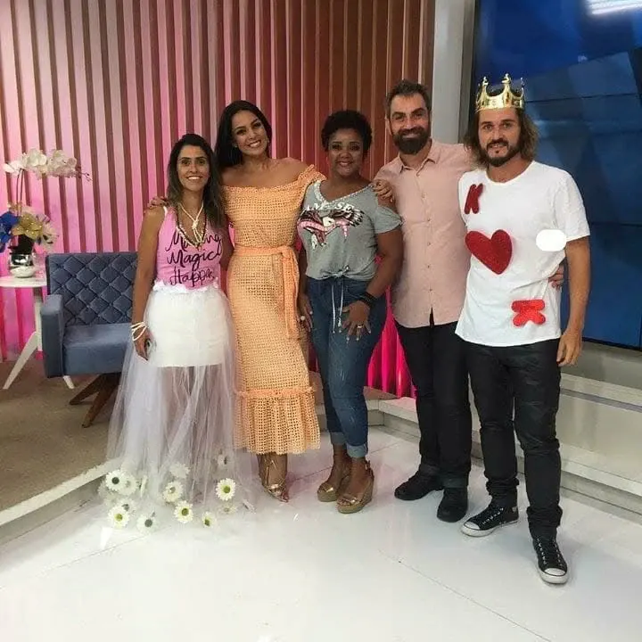 Aline Souza com a equipa num cenário de televisão.