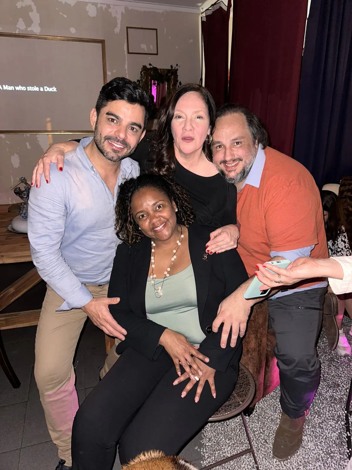Aline Souza com amigos num evento à noite.