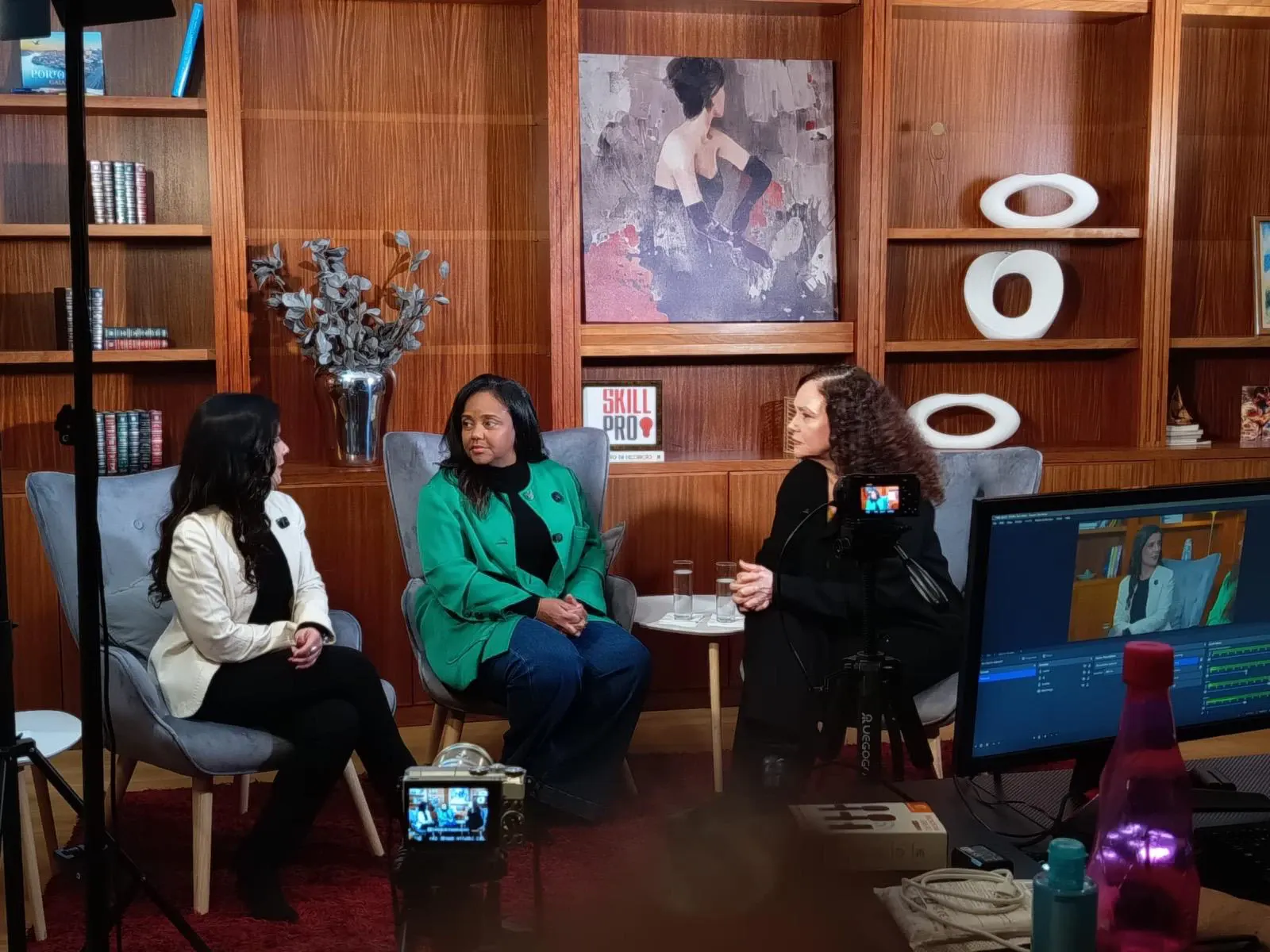 Aline Souza e Thaís de Campos num set de gravação, com câmaras e monitor em primeiro plano.