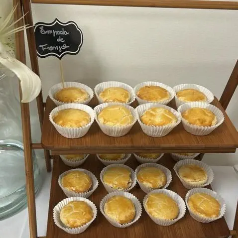 Empadas de frango servidas numa estante de madeira, no buffet do evento.